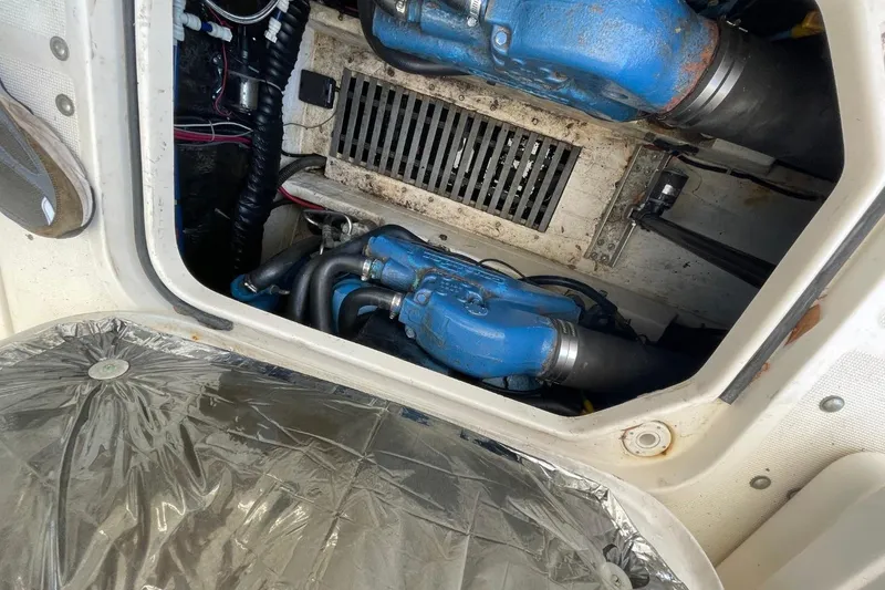 Slide: The Image of Engine compartment of a 1997 Tiara Yachts 3100 Open, featuring blue engine components. - 26