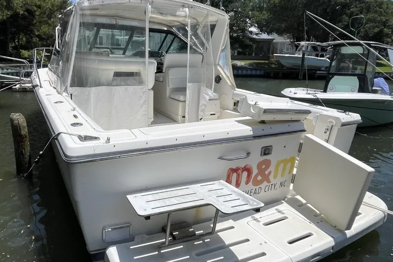 Slide: The Image of 1997 Tiara Yachts 3100 Open docked, featuring spacious deck and seating area. - 4