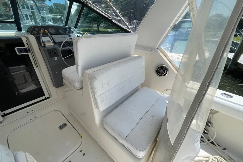 Slide: The Image of 1997 Tiara Yachts 3100 Open cockpit with white seating and steering console. - 7