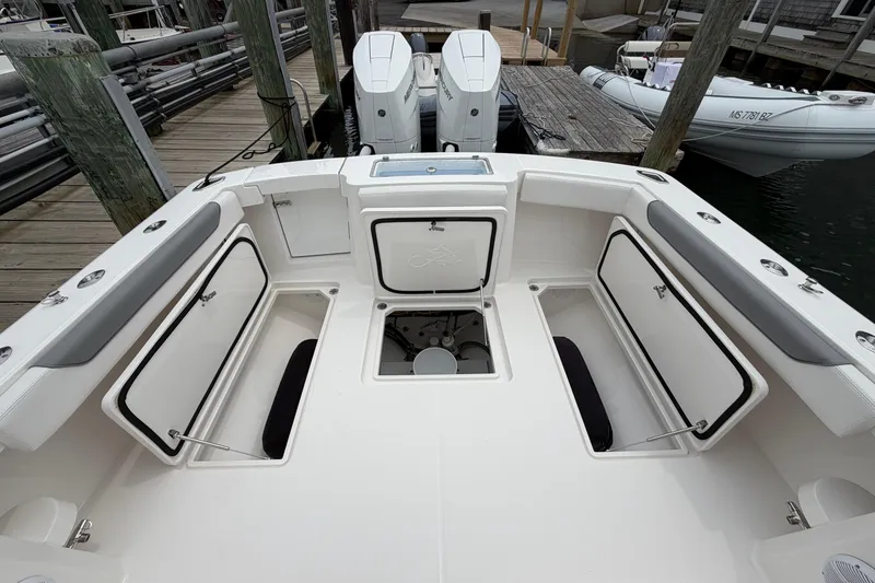 Slide: The Image of 2024 Albemarle 30 Express boat deck with open storage compartments and twin engines. - 19