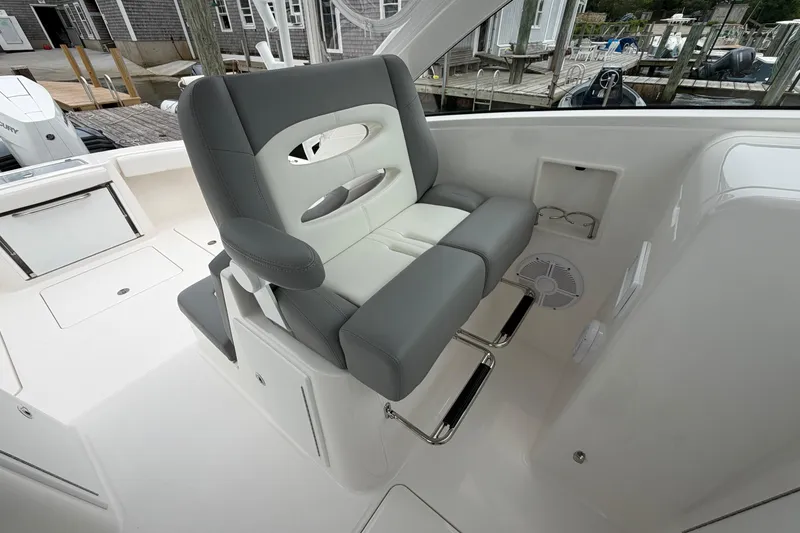 Slide: The Image of 2024 Albemarle 30 Express boat interior with gray and white seating, dockside view. - 53