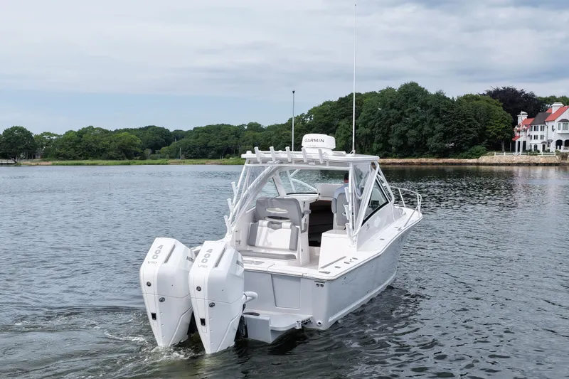 Slide: The Image of 2024 Albemarle 30 Express boat with dual outboard engines on a serene lake. - 7