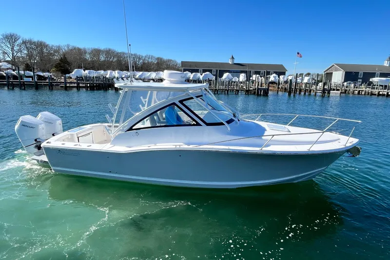 The Image of 2024 Albemarle 30 Express boat on clear water near a marina. - 0