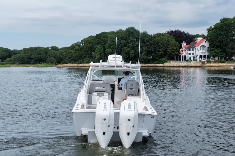 Slide: The Image of 2024 Albemarle 30 Express boat cruising on a scenic lake near a large house. - 8
