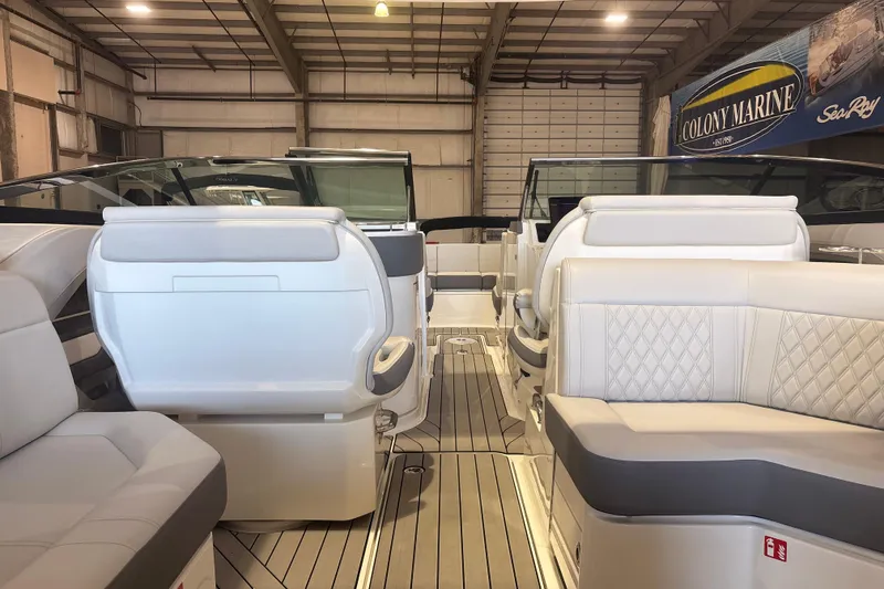 Slide: The Image of 2026 Sea Ray SLX 310 Outboard interior with luxurious seating in a showroom. - 14