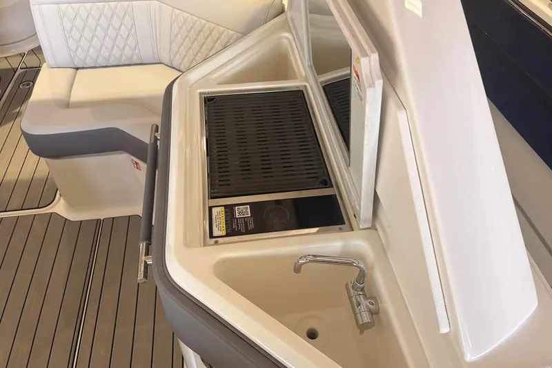 Slide: The Image of 2026 Sea Ray SLX 310 Outboard boat interior with sink and seating area. - 18
