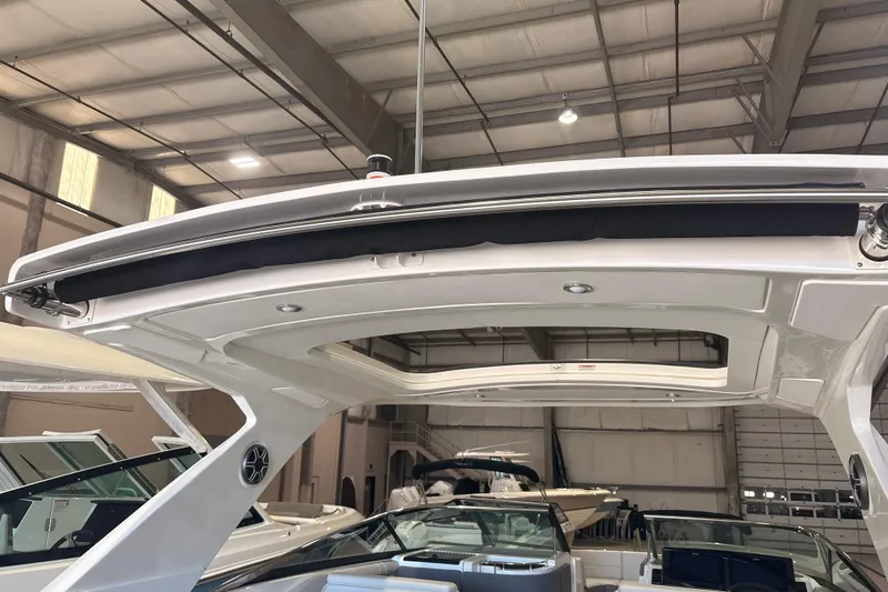 Slide: The Image of 2026 Sea Ray SLX 310 Outboard boat interior, showcasing sleek design and modern features in a showroom. - 19