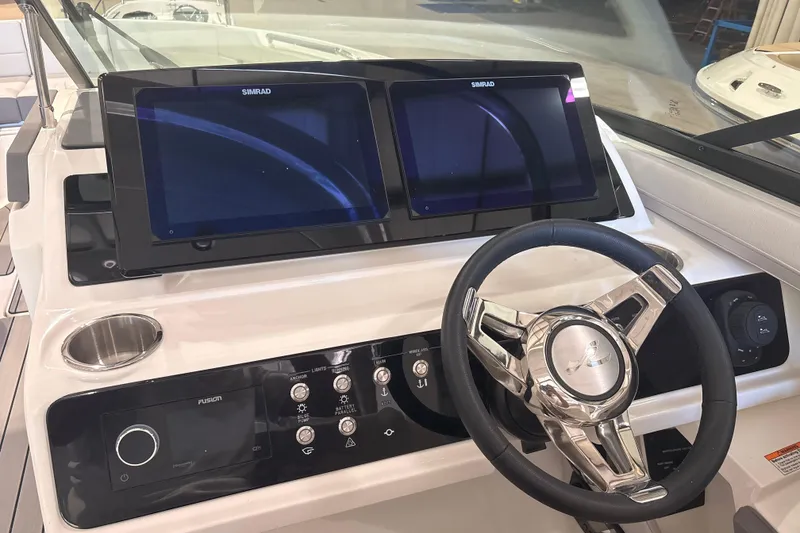 Slide: The Image of Helm of 2026 Sea Ray SLX 310 Outboard with dual Simrad displays and modern controls. - 24