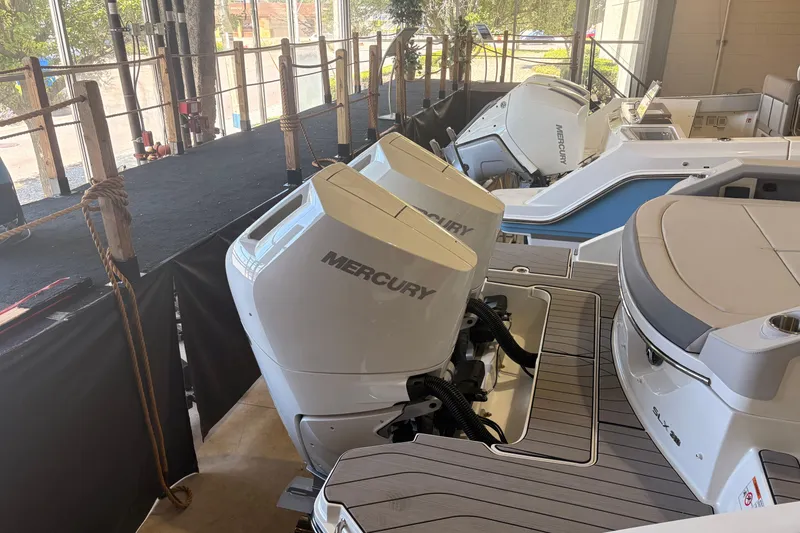 Slide: The Image of 2026 Sea Ray SLX 310 Outboard with dual Mercury engines in a showroom. - 5