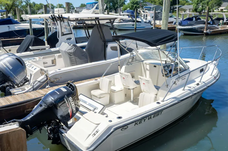 The Image of A 2012 KEYWEST 2020 WA boat docked, featuring a Suzuki outboard motor. - 1