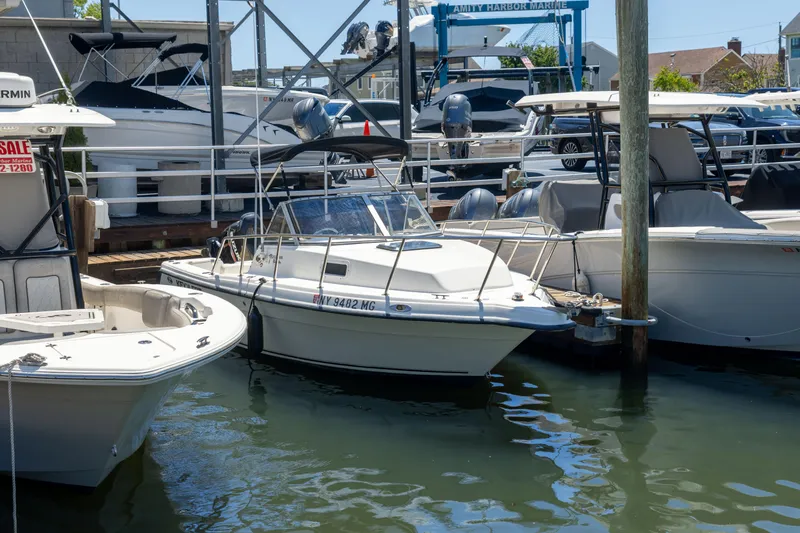 Slide: The Image of A 2012 KEYWEST 2020 WA boat docked at a marina, surrounded by other vessels. - 13