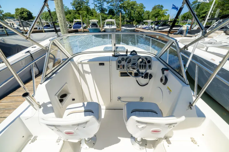Slide: The Image of Cockpit of 2012 KEYWEST 2020 WA boat, featuring dual seats and steering controls at a marina. - 4