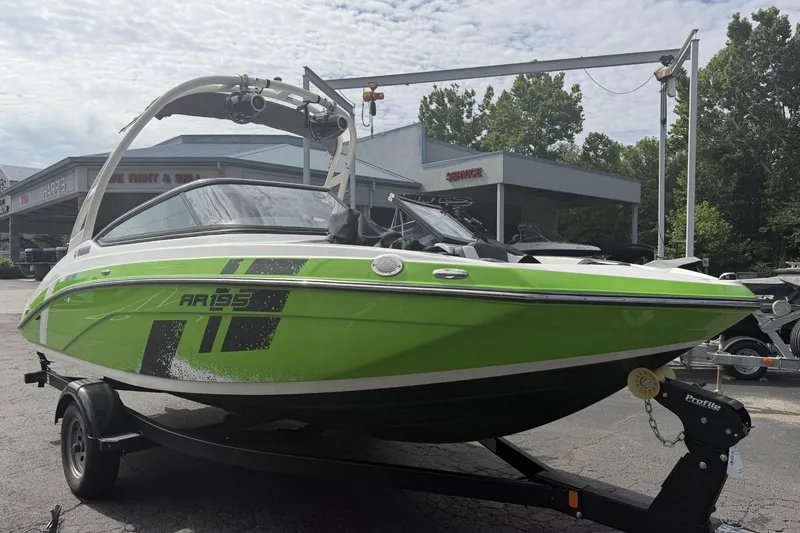 Slide: The Image of 2022 Yamaha Boats AR195 in vibrant green on trailer, parked outdoors. - 2