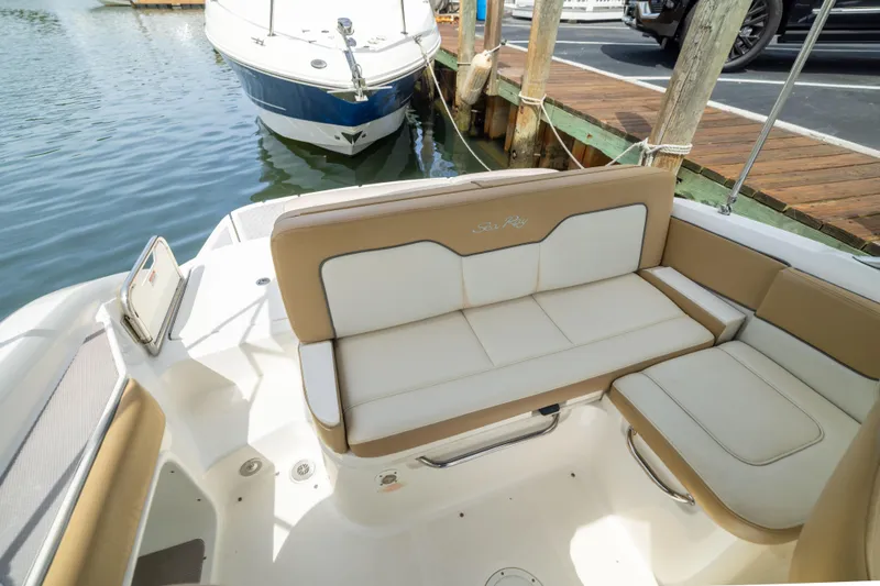 Slide: The Image of 2011 Sea Ray 220 Sundeck boat interior with beige seating at dock. - 19
