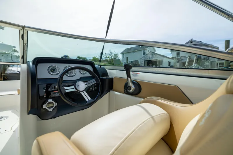 Slide: The Image of Interior view of 2011 Sea Ray 220 Sundeck boat cockpit with steering wheel and controls. - 11