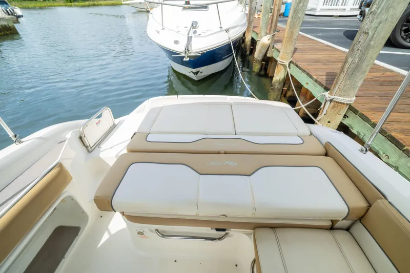 Slide: The Image of 2011 Sea Ray 220 Sundeck boat docked, featuring spacious seating and elegant design. - 22