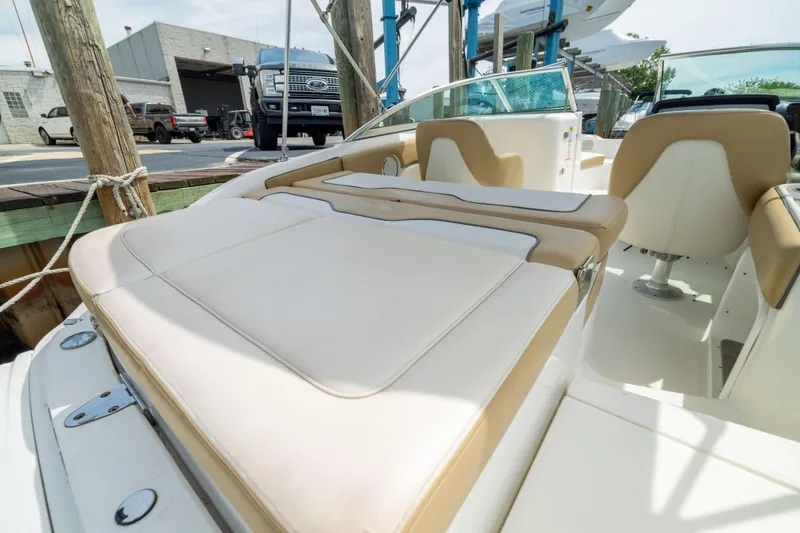 Slide: The Image of 2011 Sea Ray 220 Sundeck boat interior with beige seating and sleek design. - 23