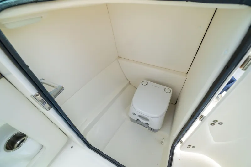 Slide: The Image of 2011 Sea Ray 220 Sundeck boat interior with compact marine toilet. - 27