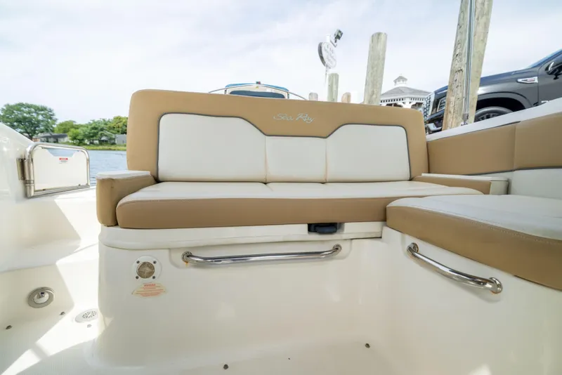 Slide: The Image of Interior seating of a 2011 Sea Ray 220 Sundeck boat, featuring beige and white upholstery. - 18