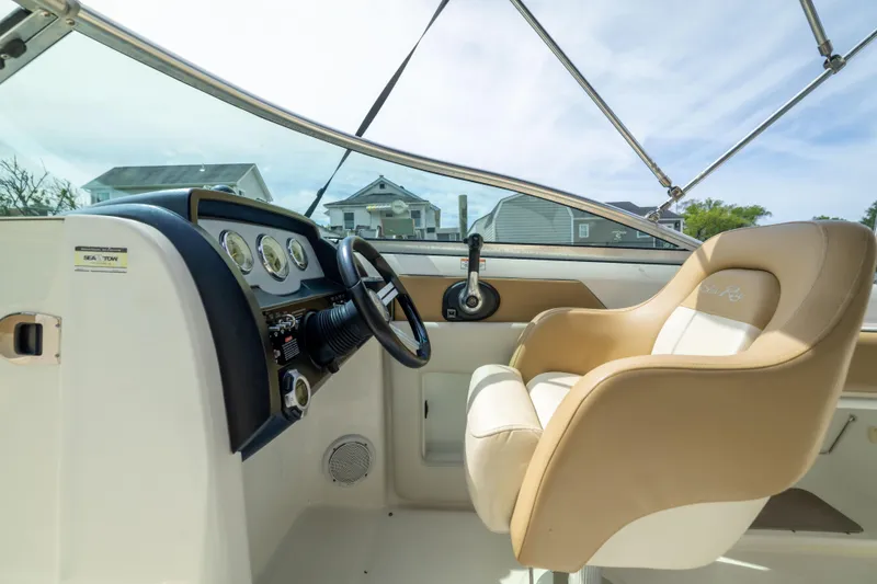 Slide: The Image of Interior view of 2011 Sea Ray 220 Sundeck boat cockpit with steering wheel and beige captain's chair. - 14