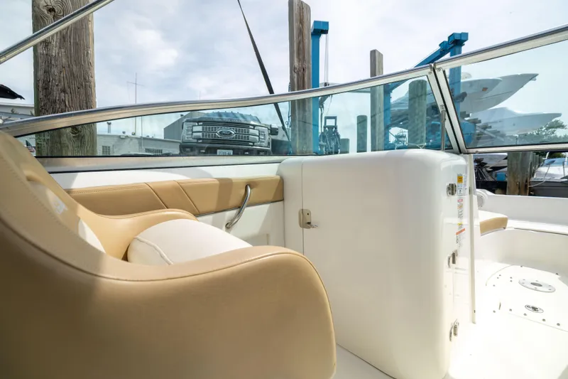 Slide: The Image of Interior view of 2011 Sea Ray 220 Sundeck boat with tan seating and glass windshield. - 12