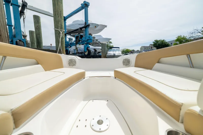Slide: The Image of 2011 Sea Ray 220 Sundeck interior with tan seating, docked at marina. - 6