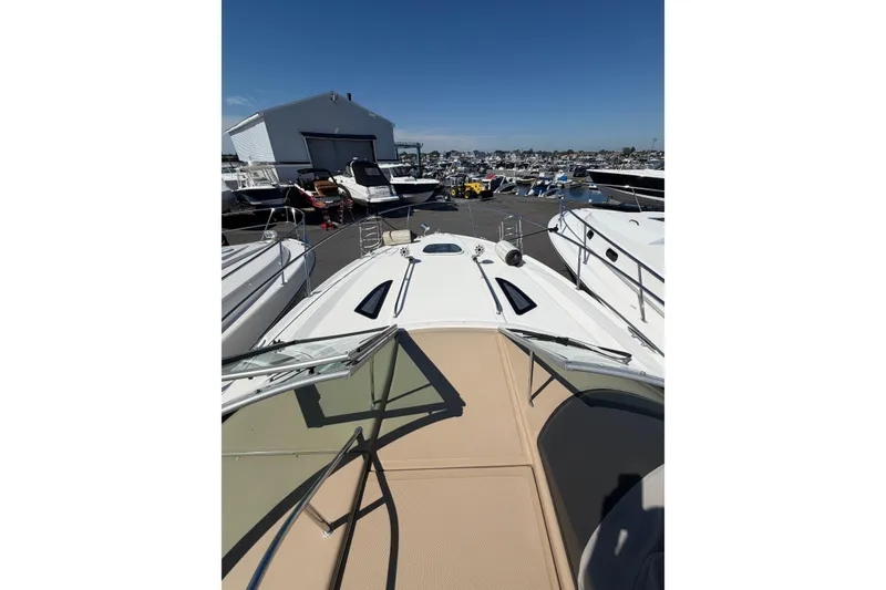 Slide: The Image of 2016 Sea Ray Sundancer 330 yacht docked at a marina under clear blue skies. - 19