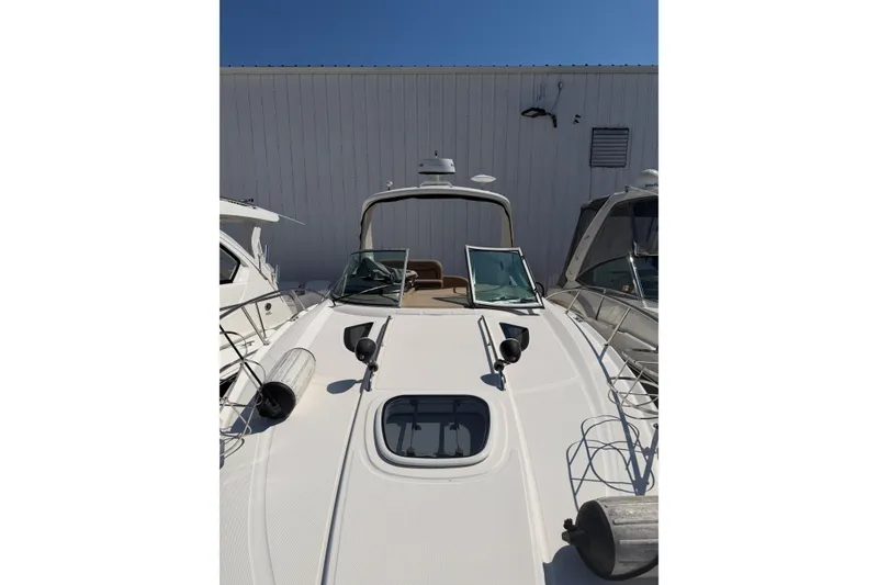 Slide: The Image of 2016 Sea Ray Sundancer 330 yacht docked, showcasing sleek design and spacious deck. - 18