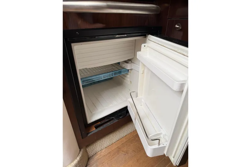 Slide: The Image of Open refrigerator inside 2016 Sea Ray Sundancer 330 yacht, showcasing interior shelves. - 24