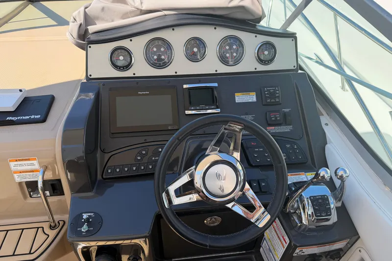 Slide: The Image of Helm of 2016 Sea Ray Sundancer 330 with steering wheel and navigation controls. - 7