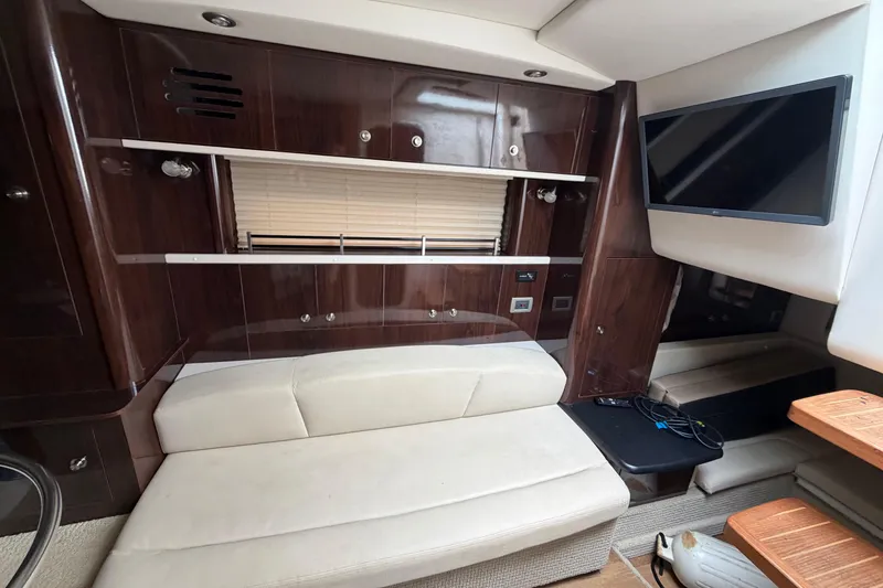 Slide: The Image of Interior of 2016 Sea Ray Sundancer 330 yacht with seating, TV, and wooden cabinetry. - 21