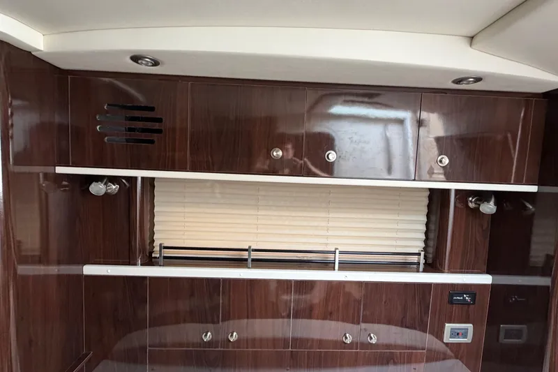 Slide: The Image of Interior of 2016 Sea Ray Sundancer 330 with wood cabinetry and window blinds. - 25