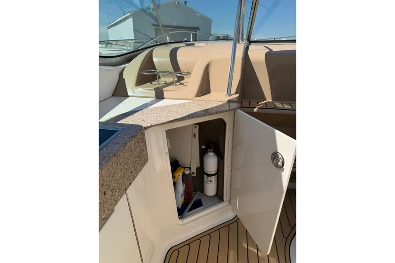Slide: The Image of 2016 Sea Ray Sundancer 330 interior with open storage compartment and fire extinguisher. - 15