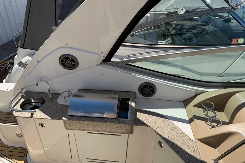 Slide: The Image of 2016 Sea Ray Sundancer 330 boat interior with kitchenette and seating area. - 10