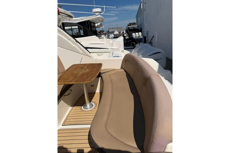 Slide: The Image of 2016 Sea Ray Sundancer 330 boat interior with seating and wooden table. - 11