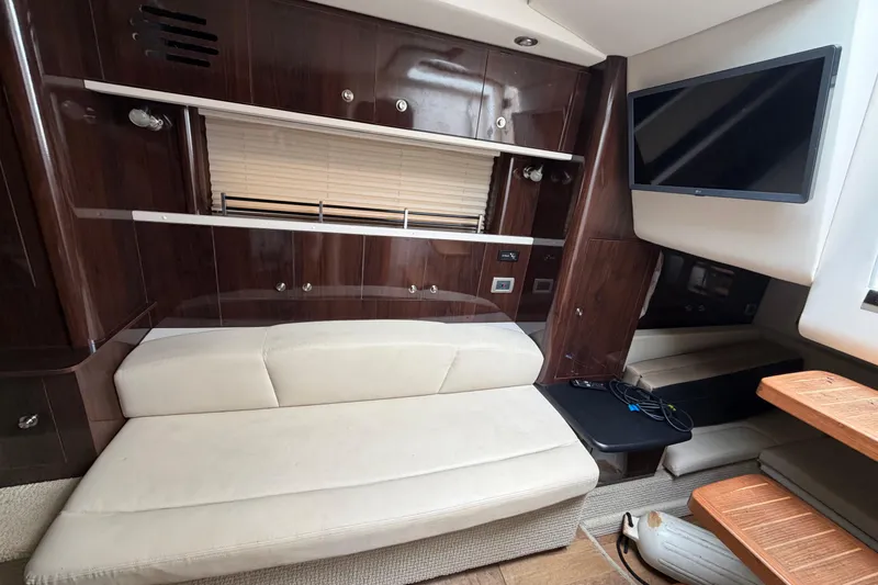 Slide: The Image of Interior of 2016 Sea Ray Sundancer 330 yacht with sofa, TV, and wooden cabinetry. - 29