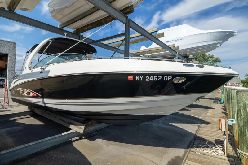 The Image of 2006 Chaparral 265 SSi boat on a dock, black and white exterior, sunny day. - 1