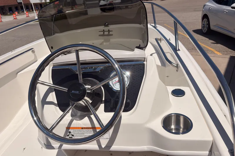 Slide: The Image of 2026 Boston Whaler Super Sport 13 boat dashboard with steering wheel and gauges. - 8
