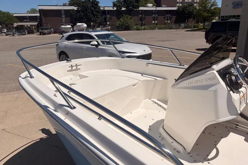 Slide: The Image of 2026 Boston Whaler Super Sport 13 boat in parking lot, showcasing sleek design and steering console. - 9