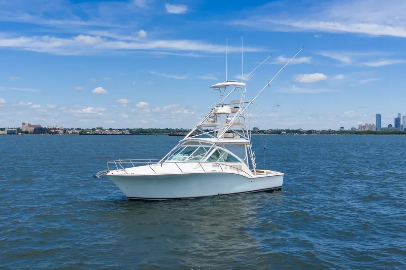The Image of A white boat with a tall helm station on calm waters under a blue sky. - 0