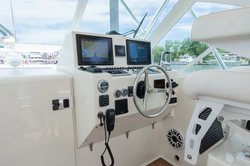 Slide: The Image of The cockpit of a 2011 Carolina Classic 32 with modern navigation systems and controls. - 12