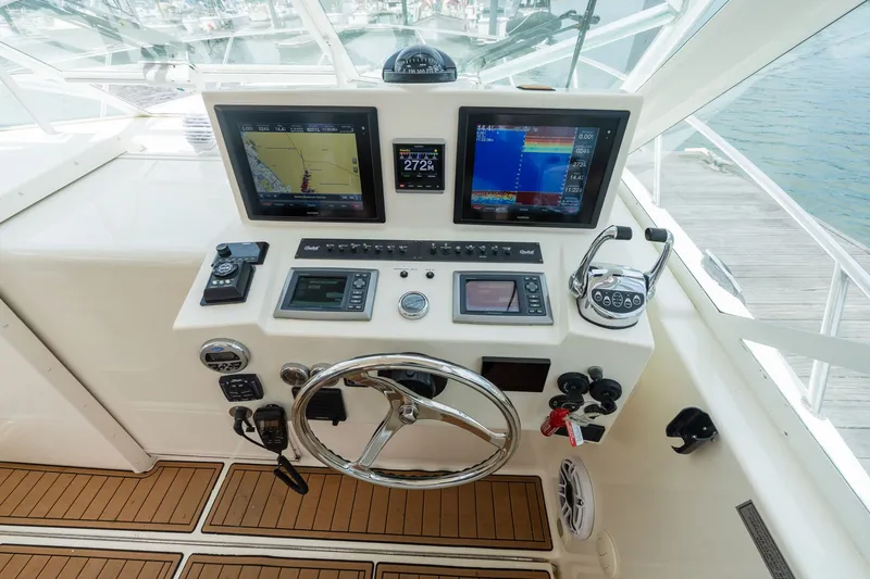 Slide: The Image of The cockpit of a 2011 Carolina Classic 32 with modern navigation equipment and a steering wheel. - 13