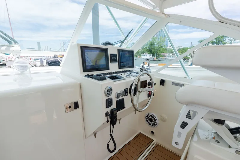 Slide: The Image of The cockpit of a 2011 Carolina Classic 32 with steering wheel, instruments, and screens. - 14