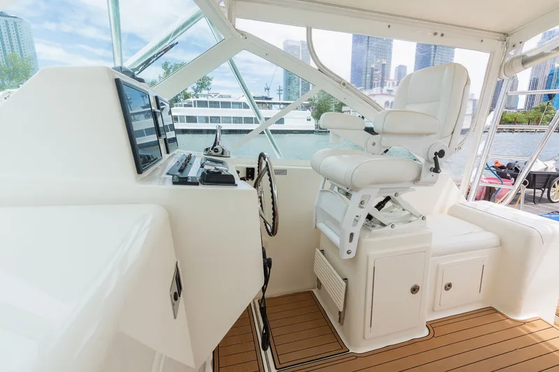 Slide: The Image of The cockpit of a 2011 Carolina Classic 32 with a helm station and white captain's chair. - 15