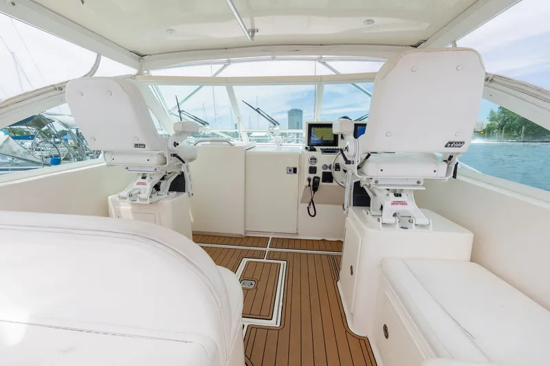 Slide: The Image of The cockpit of a 2011 Carolina Classic 32 with two white captain's chairs and wooden flooring. - 17