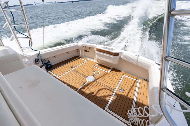 Slide: The Image of The boat features a spacious deck with wooden flooring, cruising on the water. - 25