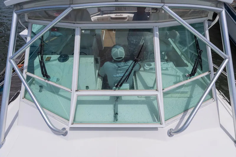 Slide: The Image of A boat with a covered helm and large windows, situated on the water. - 26