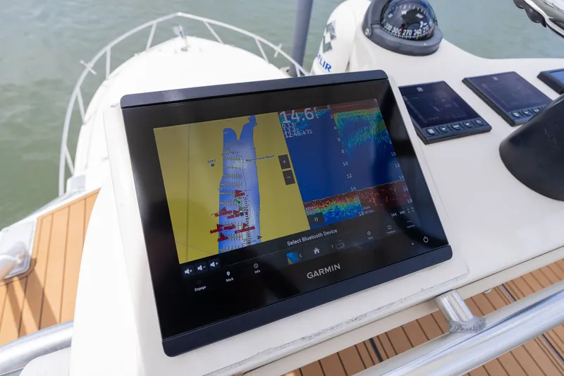 Slide: The Image of A Garmin navigation system on a boat with wooden flooring and a compass. - 31
