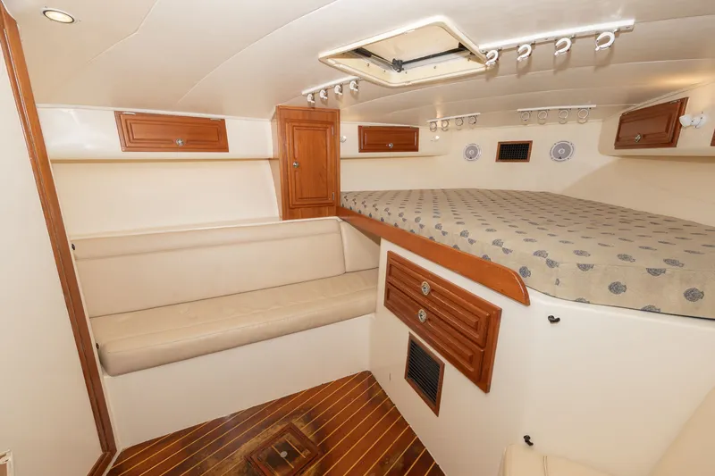 Slide: The Image of Interior of a 2011 Carolina Classic 32 with wooden flooring and cushioned bed. - 5