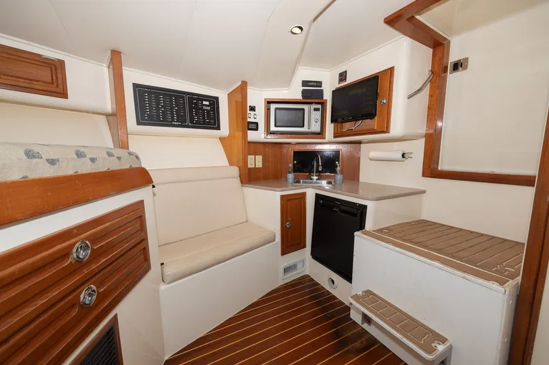 Slide: The Image of Interior of a 2011 Carolina Classic 32 with a kitchenette and seating area. - 7